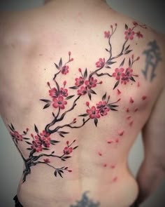 the back of a woman's body with red flowers and leaves on her chest