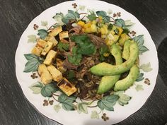 a white plate topped with meat and vegetables