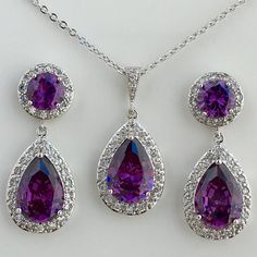 Luxury top quality purple amethyst cubic zirconia bridal set includes : # Earrings featuring a large teardrop with pear cut purple amethyst cubic zirconia center surrounded by tiny round zirconia crystals. Teardrop dangles from a ear stud with brilliant cut purple amethyst cubic zirconia center and surrounded by tiny round zirconia crystals. This entire halo setting gives a brilliantly beautiful effect. Total length of the earrings is 3.5 cms. #Necklace pendant featuring a large teardrop with pe Purple Jewelry Set, Purple Wedding Jewelry, Purple Accessories, Amethyst Set, Fancy Jewellery Designs, Bridal Jewelry Set, Purple Diamond, Diamond Jewelry Necklace, Purple Jewelry