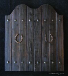 an old wooden door with two horseshoes on the front and one in the back