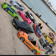 a group of cars parked next to each other in front of a body of water