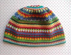 a multicolored crocheted hat sitting on top of a table