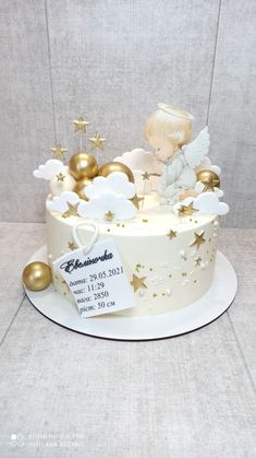 a white cake with gold stars and an angel on top