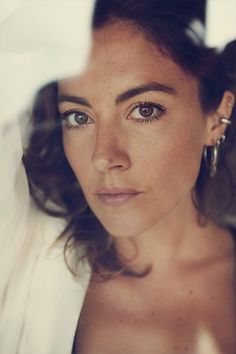 a close up of a person with very large hoop earrings on her head and brown eyes