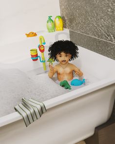 a child sitting in a bathtub with toys