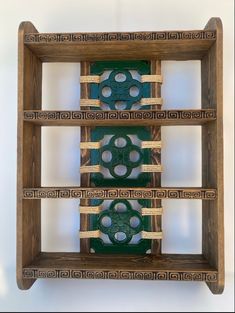 an art piece made out of wood and green material with holes in the bottom part