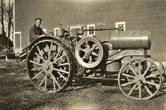 an old photo of a man sitting on top of a tractor