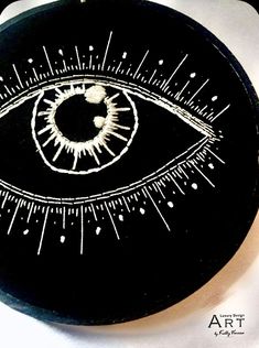 a black and white clock with an eye drawn on it