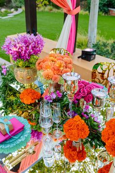 the table is set with flowers and wine glasses for an outdoor party or wedding reception