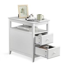 an end table with drawers and a cup on top, next to a framed photograph