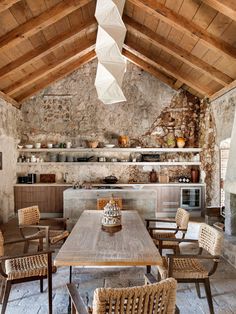 an old stone kitchen with wooden tables and wicker chairs, built into the ceiling