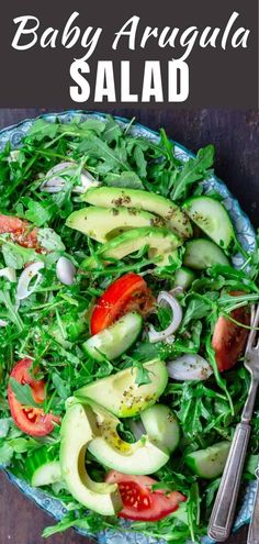 a salad with avocado, tomatoes and spinach on it in a bowl