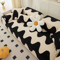 a black and white cow print couch with a flower on it's back cover