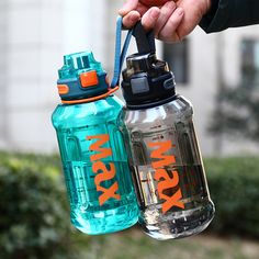 two water bottles are being held by someone