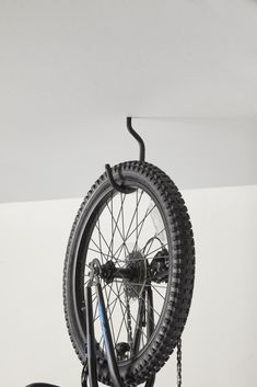 there is a bike hanging on the wall with chains attached to it's wheels