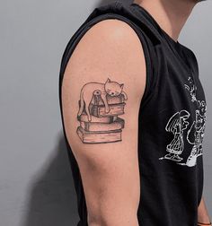 a man with a cat tattoo on his arm next to a book and an elephant