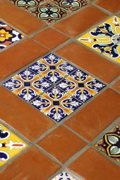 an orange and blue tiled floor with different designs on it's sides, as well as the bottom part of the tile