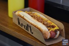 a hot dog with mustard and ketchup in a cardboard box on a table