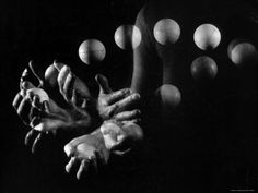 black and white photograph of two hands reaching out towards each other with circles in the background