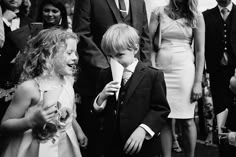 a group of people standing next to each other in front of a boy wearing a suit and tie