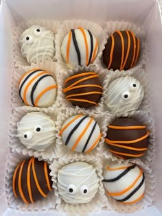 a box filled with chocolates covered in white and orange striped frosted candy balls