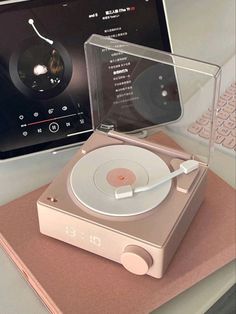 a record player sitting on top of a table next to a laptop