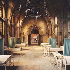 an old church with many beds and chairs in it's center aisle, as well as a chandelier hanging from the ceiling