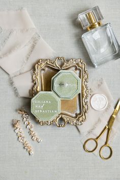 an assortment of personal items are laid out on a table with lace, scissors and perfume bottles