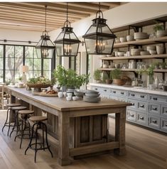 a kitchen with lots of counter space and hanging lights