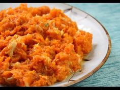 a white plate topped with mashed carrots on top of a blue table cloth