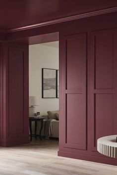 a living room with red walls and wooden floors