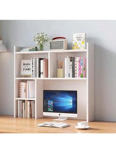 a computer monitor sitting on top of a white book shelf next to a keyboard and mouse