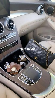 the interior of a luxury car with an electronic device and other items in its compartment