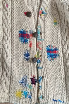 a white sweater with colorful designs on it