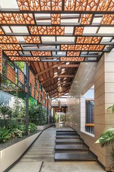 the inside of a building with stairs leading up to it and plants on either side