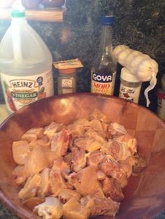 a wooden bowl filled with meat next to bottles of milk and other ingredients on a counter