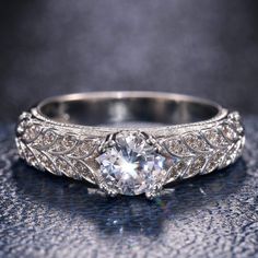 an antique style diamond engagement ring with filigrees