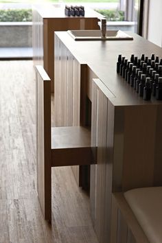 a wooden table with bottles on it in front of a window