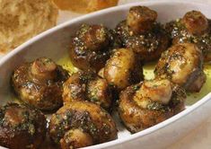 a white bowl filled with meatballs next to bread