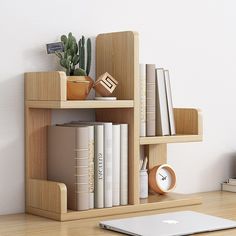 an apple computer sitting on top of a wooden shelf next to a bookshelf