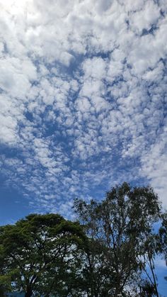 the sky is filled with clouds and trees