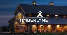 a barn with the words timberline lit up at night in front of it's windows