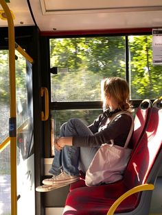 a woman sitting on a bus looking out the window