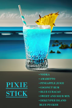 a blue drink sitting on top of a table next to the ocean