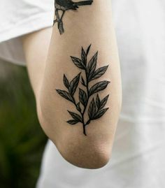 a woman's arm with a bird and leaves tattoo on the left side of her body