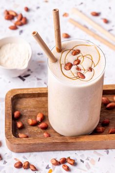 there is a drink with almonds on the side and cinnamon sticks sticking out of it