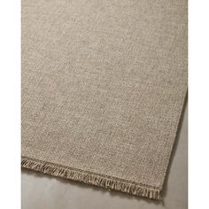 a beige rug with fringes on it