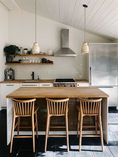 a kitchen with two wooden chairs at the counter