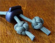 two blue and white ropes on a wooden table with one knoted up to the end