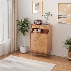 a living room with white walls and wooden furniture in the corner, along with potted plants